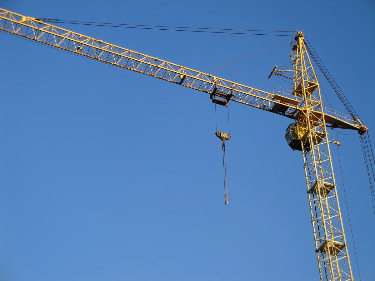 Grúa torre recortada contra el cielo en una obra en altura